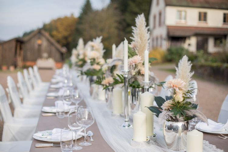 Silberne Vase mit apricot farbenen Blumen, Federn und Blattgrün, Spitzentischdecke, personalisierter Wein, silberne Kerzenstände