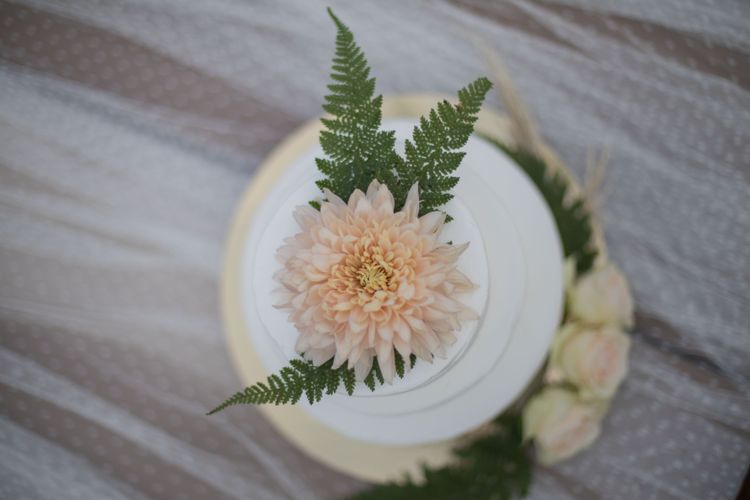 Hochzeitstorte mit Blattgrün und Apricotfarbenen Blumen dekoriert
