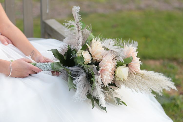 Brautstrauß mit apricot farbenen Blumen und Federn, Griff mit Spitze verziert